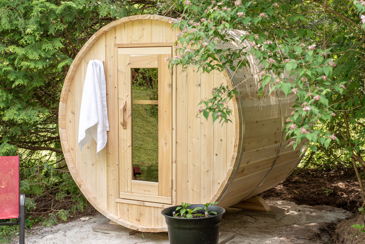 Harmony Barrel Sauna in backyard with flowering shrubs